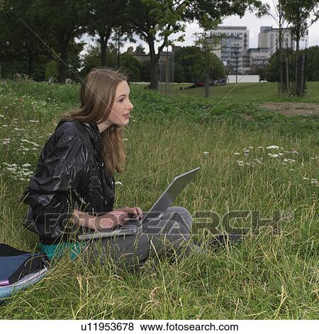 Young woman with laptop outside View Large Photo Image Stock Photo - Young woman with laptop outside. Fotosearch