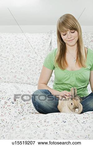 Young woman with pet rabbit View Large Photo Image Stock Photo - Young woman with pet rabbit. Fotosearch