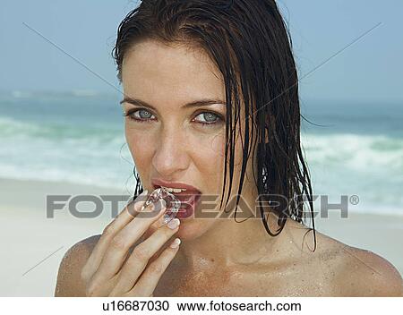 Young women biting into ice cube View Large Photo Image Stock Image - Young women biting into ice cube. Fotosearch