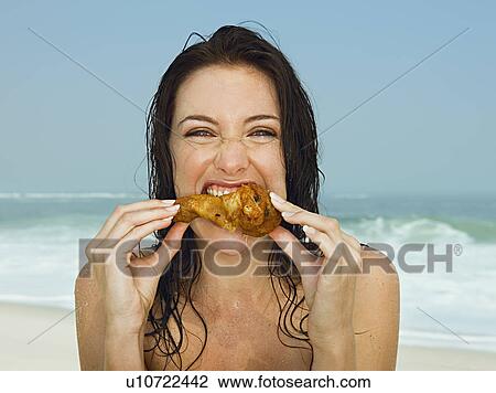 Young women eating a chicken leg View Large Photo Image Stock Image - Young women eating a chicken leg. Fotosearch