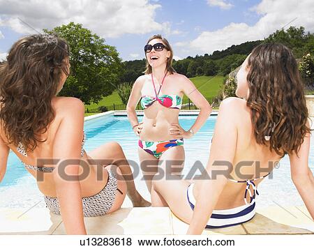 Stock Photo - young women gossiping in pool. Fotosearch