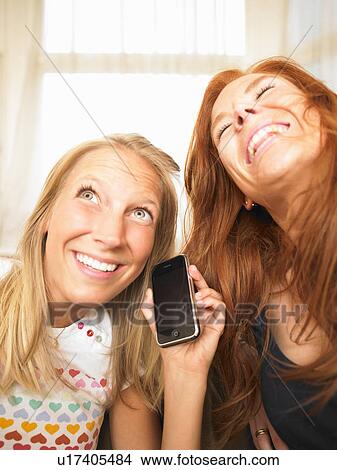 Picture - young women using phone. Fotosearch