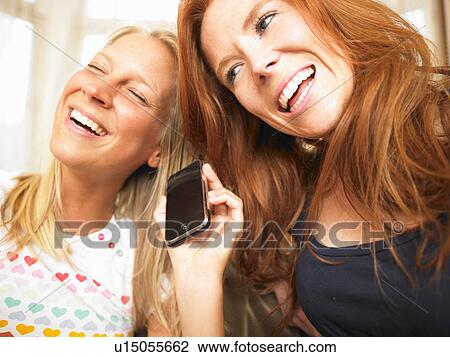 Stock Image - young women using phone. Fotosearch