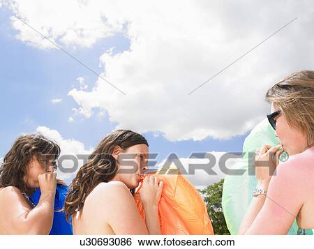 Stock Photograph - young women with pool mattresses. Fotosearch