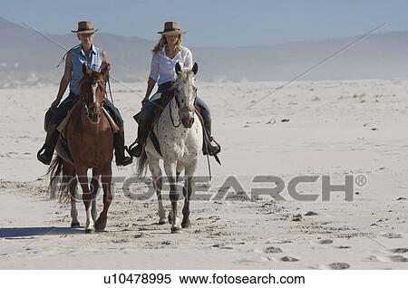 2 people riding horses on the beach View Large Photo Image Stock Photography - 2 people riding horses on the beach. Fotosearch