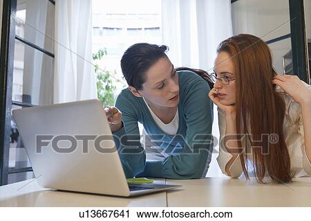 Stock Image - 2 women looking at a laptop. Fotosearch