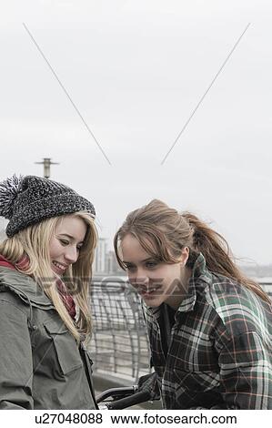 2 young women chatting and laughing View Large Photo Image Stock Photo - 2 young women chatting and laughing. Fotosearch