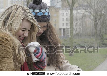 2 young women having a take away drink View Large Photo Image Stock Photograph - 2 young women having a take away drink. Fotosearch