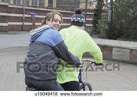 2 young women on 1 pushbike View Large Photo Image Stock Photo - 2 young women on 1 pushbike. Fotosearch