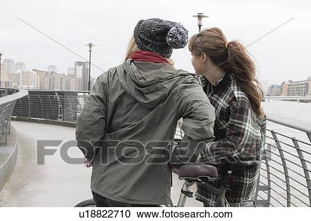2 young women with push bikes View Large Photo Image Stock Image - 2 young women with push bikes. Fotosearch