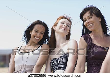 Stock Photograph - 3 Girl friends for blue sky having fun. Fotosearch