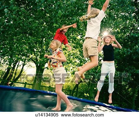 Stock Photography - 4 children leaping on trampoline. Fotosearch