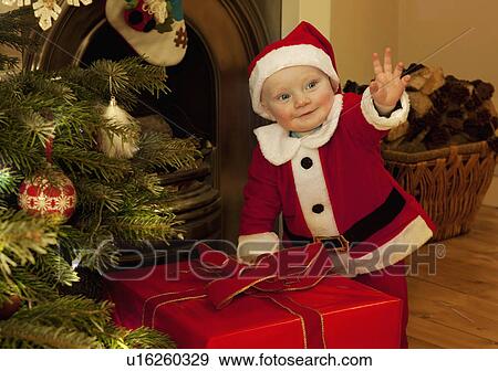 A baby santa standing next to a present View Large Photo Image Stock Photo - A baby santa standing next to a present. Fotosearch
