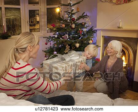 A boy giving his Mum a Christams present View Large Photo Image Stock Image - A boy giving his Mum a Christams present. Fotosearch