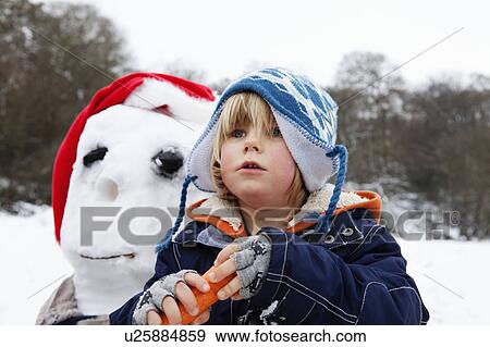A boy with a carrot for a snowmans nose View Large Photo Image Stock Photo - A boy with a carrot for a snowmans nose. Fotosearch
