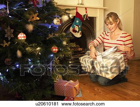 A woman opening a Christmas present View Large Photo Image Stock Image - A woman opening a Christmas present. Fotosearch