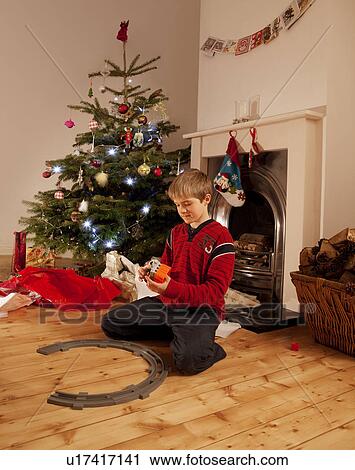 A young boy playing with a train set View Large Photo Image Stock Image - A young boy playing with a train set. Fotosearch