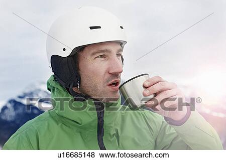Stock Photo - Alpinist on mountain drinking. Fotosearch