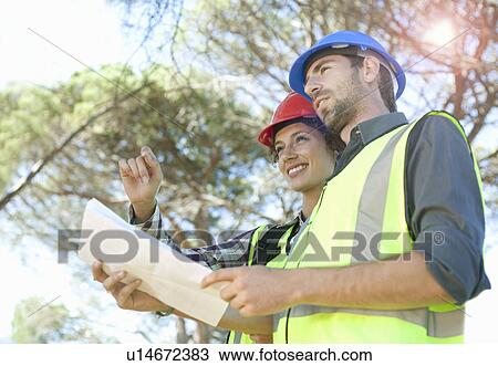 Stock Image - Architect and engineer discussing plans. Fotosearch