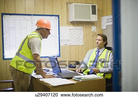 Stock Image - Architect talking to a building worker. Fotosearch