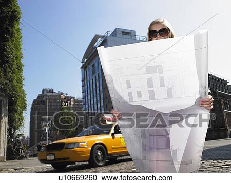 Stock Image - Architect with blue prints in the street. Fotosearch