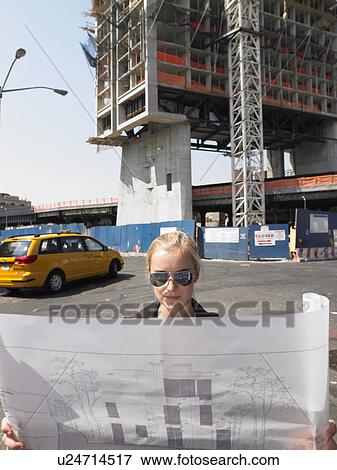 Stock Photo - Architect with blue prints in the street. Fotosearch
