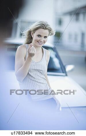 Picture - Attractive woman standing infront of car. Fotosearch