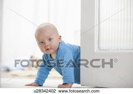 Stock Image - Baby boy crawling around door. Fotosearch