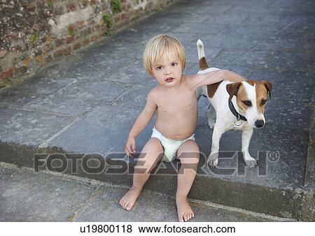 Stock Photo - Baby boy playing with a dog. Fotosearch