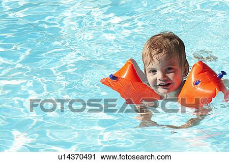 Baby boy swimming with water wings View Large Photo Image Stock Image - Baby boy swimming with water wings. Fotosearch