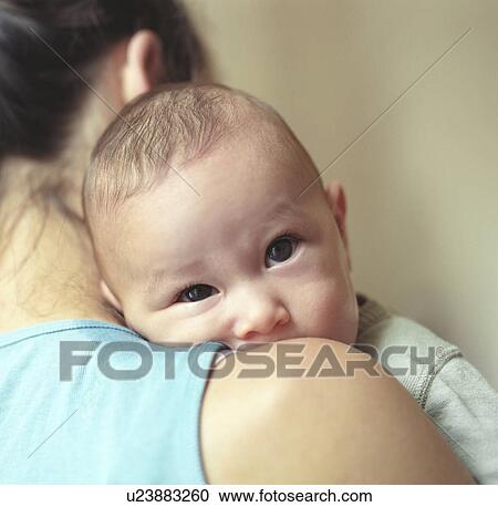 Stock Image - baby looking over mother's shoulder. Fotosearch