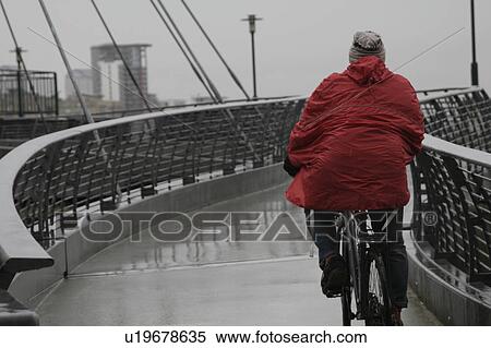 Back view of man with raincoat cycling View Large Photo Image Stock Photography - Back view of man with raincoat cycling. Fotosearch