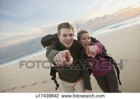 Stock Image - Backpacking couple pointing at camera. Fotosearch