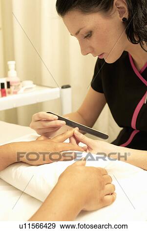 Beautician performing manicure View Large Photo Image Stock Photo - Beautician performing manicure. Fotosearch