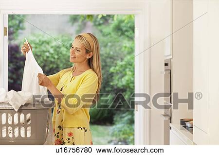 Beautiful young housewife doing laundry View Large Photo Image Stock Image - Beautiful young housewife doing laundry. Fotosearch