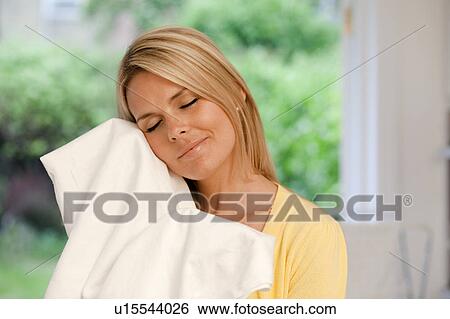 Stock Photograph - Beautiful young housewife doing laundry. Fotosearch