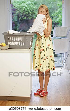 Stock Photograph - Beautiful young housewife doing laundry. Fotosearch
