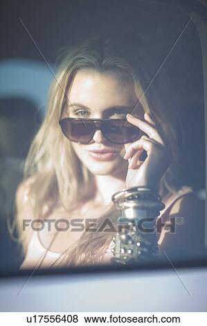 Stock Photo - Blond girl with shades in car. Fotosearch