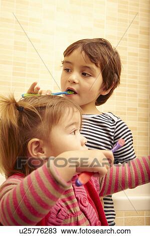 Boy and girl brushing teeth in bathroom View Large Photo Image Stock Image - Boy and girl brushing teeth in bathroom. Fotosearch
