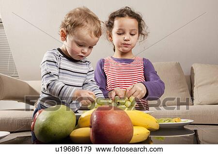 Boy and girl eating fruit View Large Photo Image Stock Photo - Boy and girl eating fruit. Fotosearch