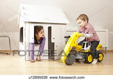 Boy and girl in front of cardboard house View Large Photo Image Stock Photo - Boy and girl in front of cardboard house. Fotosearch