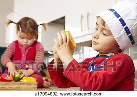 Stock Image - Boy and girl looking at vegetables. Fotosearch