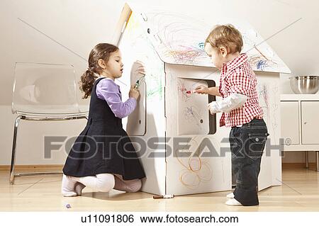 Boy and girl painting cardboard house View Large Photo Image Stock Photograph - Boy and girl painting cardboard house. Fotosearch