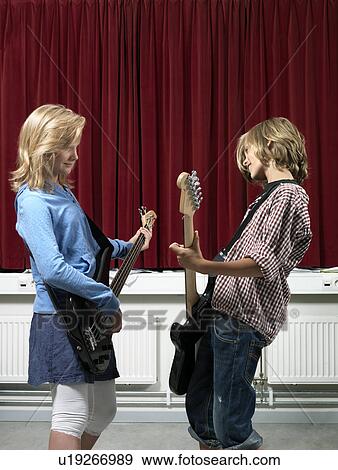 Boy and girl playing guitar View Large Photo Image Stock Photo - Boy and girl playing guitar. Fotosearch