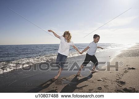 Boy and girl running on beach View Large Photo Image Stock Photo - Boy and girl running on beach. Fotosearch