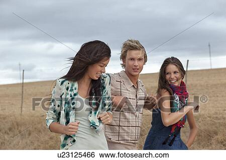 Stock Photograph - Boy between two girls fighting. Fotosearch