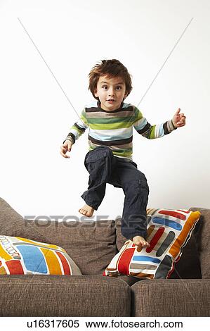 Boy jumping on sofa View Large Photo Image Stock Photography - Boy jumping on sofa. Fotosearch