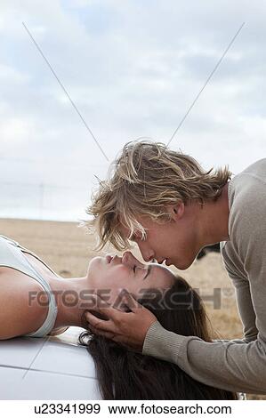 Stock Photo - Boy kissing girls forehead. Fotosearch