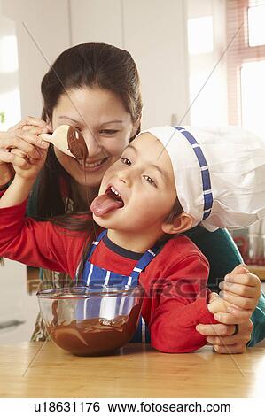 Boy licking chocolate off spoon with mum View Large Photo Image Stock Photograph - Boy licking chocolate off spoon with mum. Fotosearch