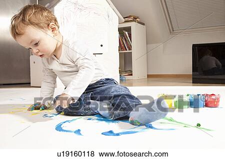 Stock Photo - Boy playing with finger paint. Fotosearch